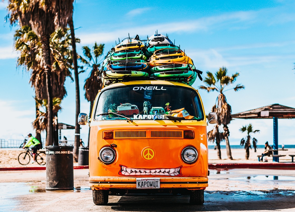Orange volkswagen van with surfboards 