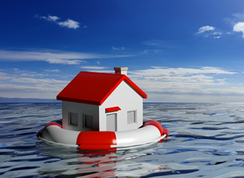 a small life raft with a plastic model of a house in a body of water