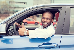Man driver showing thumbs up driving sport blue car