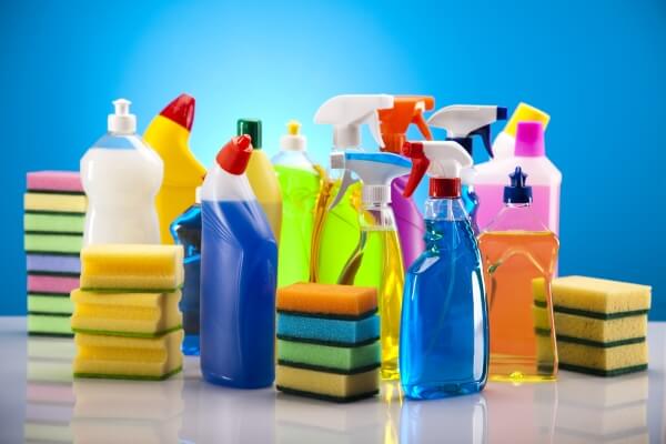 Several bottles of cleaning products and several stacks of sponges