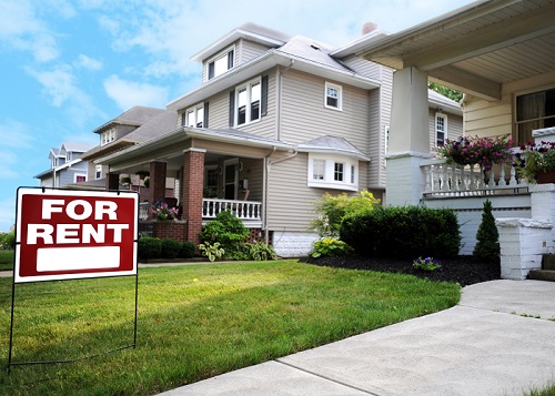 Red for rent sign in the front yard of a two-story single family home in a neighborhood